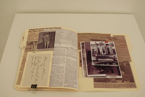 A file folder with images and newspaper clippings