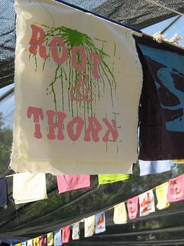 Detail of handmade pennant flags on scrap material with silkscreened text reading "Toot and Thorn"